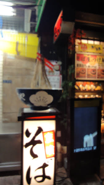 the sign for a ramen shop that uses what looks like a mop to represent the noodles